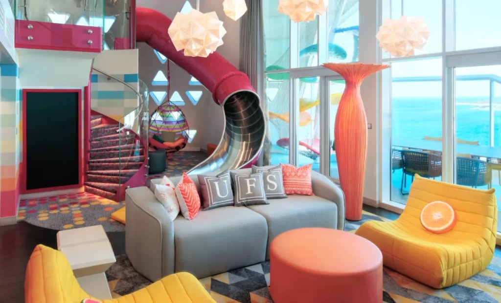 family suite in a cruise ship with colorful sofas kids playing area and ocean view