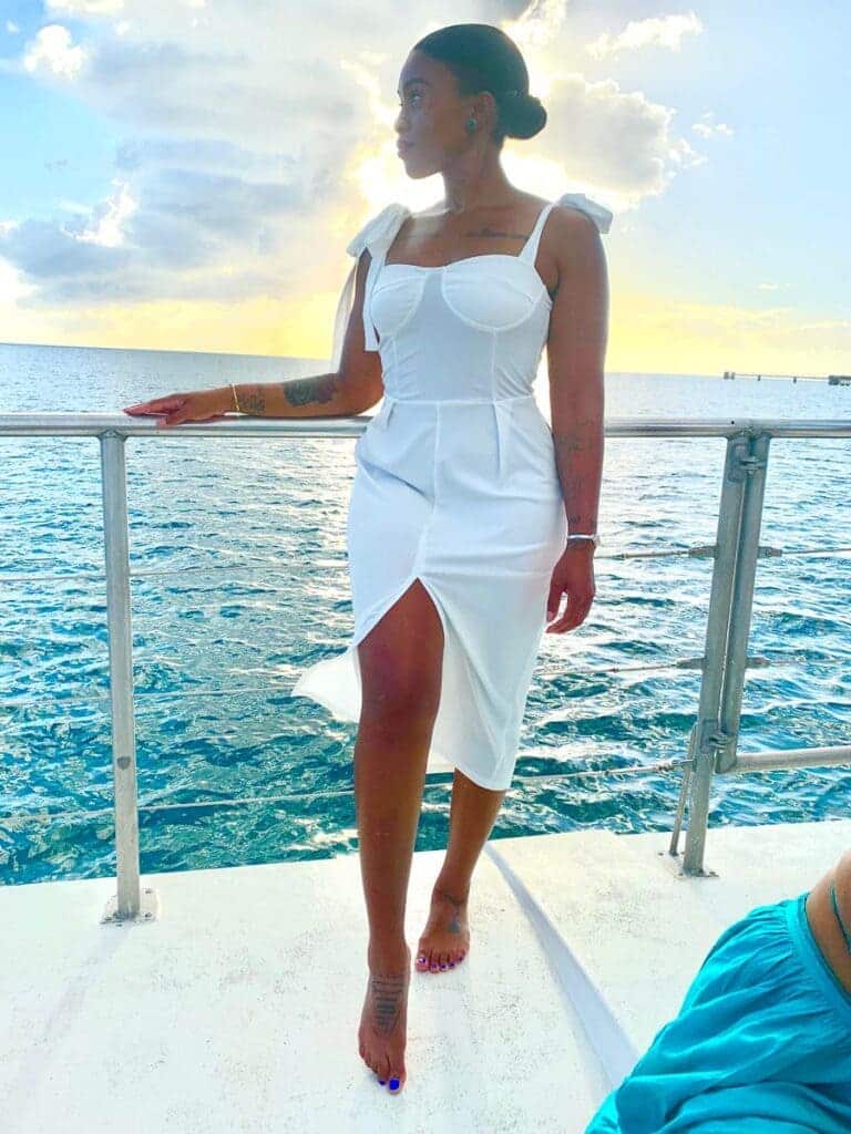 girl styling white dress on a ship in waters