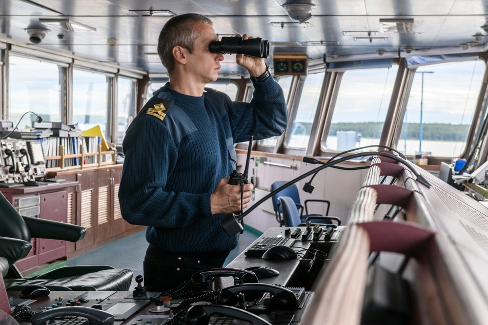 Deck Officer With Binoculars On Navigational Bridge Seaman On Board